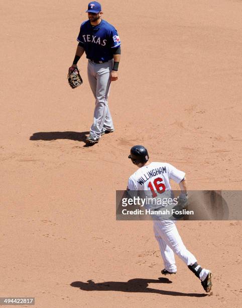 Mitch Moreland of the Texas Rangers looks on as Josh Willingham of the Minnesota Twins rounds the bases after hitting a two run home run during the...