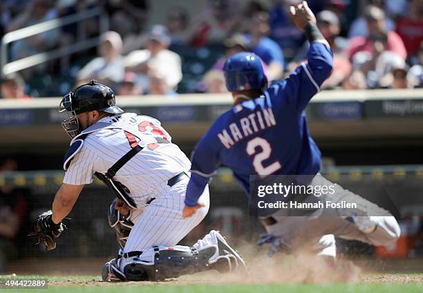 Leonys Martin of the Texas Rangers slides safely as Josmil Pinto of the Minnesota Twins defends home plate during the eighth inning of the game on...