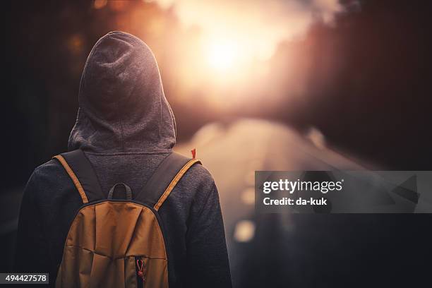 reisende mit rucksack zu fuß nach vorn, allein bei sonnenuntergang - the way forward stock-fotos und bilder