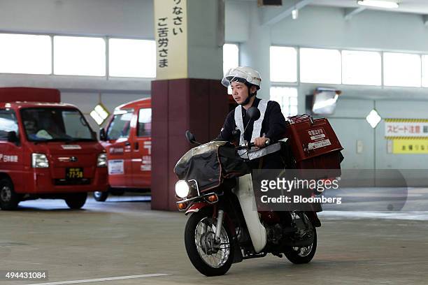 Mail carrier rides a motorcycle as he departs from a Japan Post Co. Post office in Tokyo, Japan, on Monday, Oct. 26, 2015. Japan Post Holdings and...