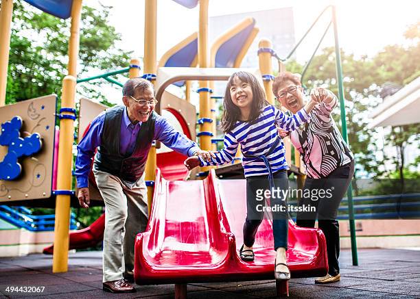 granddaughter, grandfather and grandmother at playground - hong kong grandmother stock pictures, royalty-free photos & images