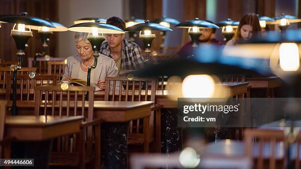 people sitting in public library - openbare bibliotheek stockfoto's en -beelden