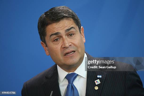 Honduran President Juan Orlando Hernandez speaks to the media with German Chancellor Angela Merkel following talks at the Chancellery on October 27,...