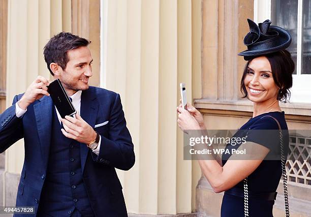 Frank Lampard poses with partner Christine Bleakley as he holds his Officer of Order of the British Empire medal, after it was presented to him by...