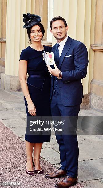 Frank Lampard poses with partner Christine Bleakley as he holds his Officer of Order of the British Empire medal, after it was presented to him by...