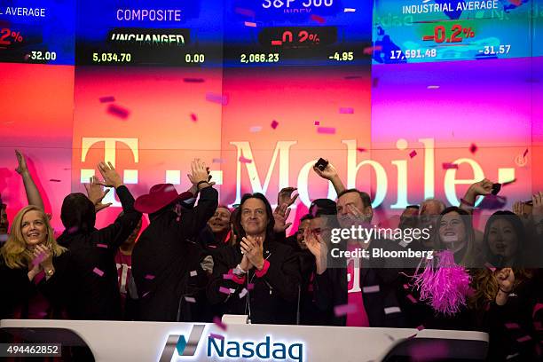 John Legere, chief executive officer of T-Mobile US Inc., center, applauds after ringing the opening bell at the Nasdaq MarketSite in New York, U.S.,...