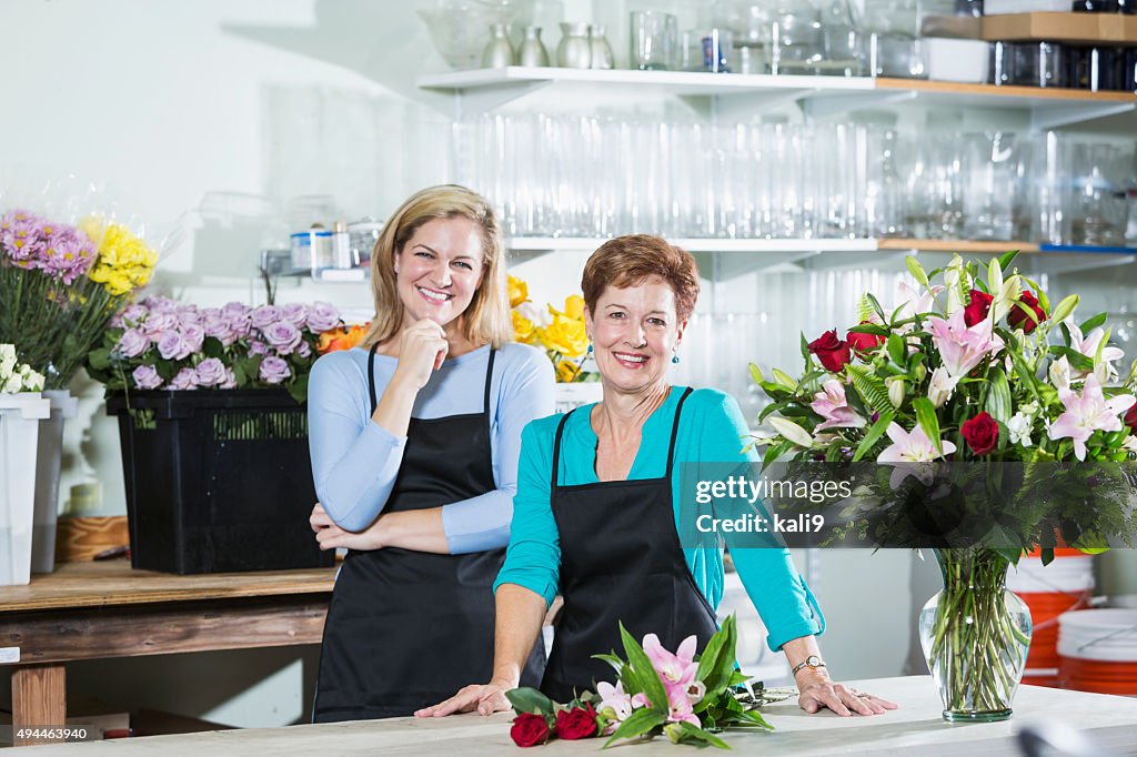 Zwei Frauen arbeiten im Blumen-shop mit Schürzen