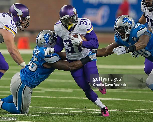 Jerick McKinnon of the Minnesota Vikings is tackled by Stephen Tulloch of the Detroit Lions during an NFL game at Ford Field on October 25, 2015 in...