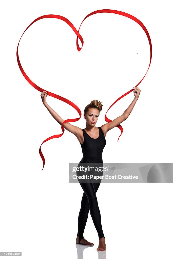 Dancer with large red ribbon shaped as a heart