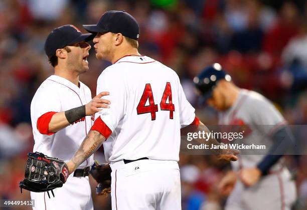 Jake Peavy of the Boston Red Sox is held back by teammate Dustin Pedroia during an argument with umpire Bob Davidson in the fourth inning against the...