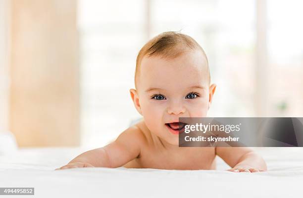 cute baby in bed smiling and looking at camera. - baby happy cute smiling baby only stock pictures, royalty-free photos & images