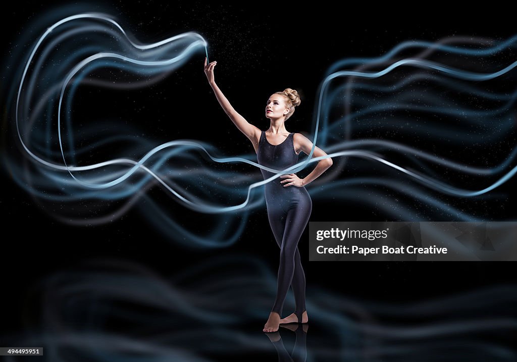 Gymnast waving blue ribbons with high speed motion