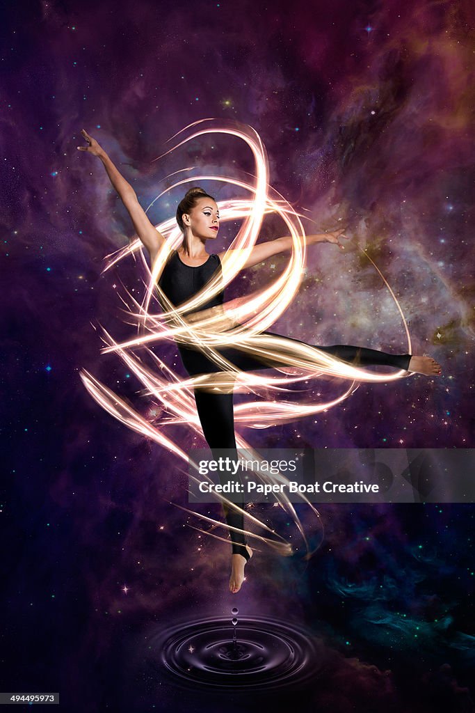 Dancer in electric waves around her in cosmic sky