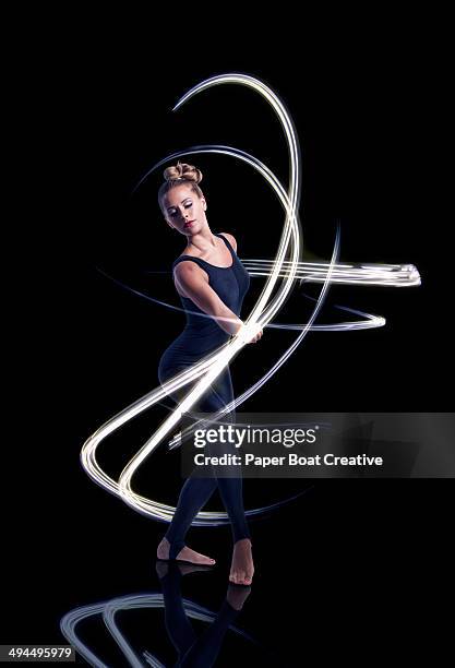 dancer making elegant light waves around her - long exposure dancer stock-fotos und bilder