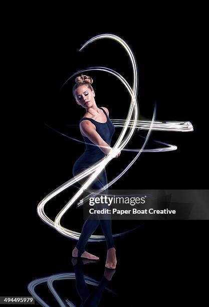 dancer making elegant light waves around her - long exposure dance stock pictures, royalty-free photos & images