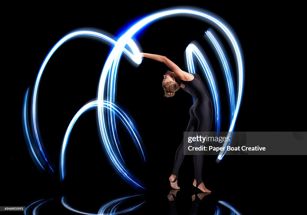 Gymnast making electric blue light streaks