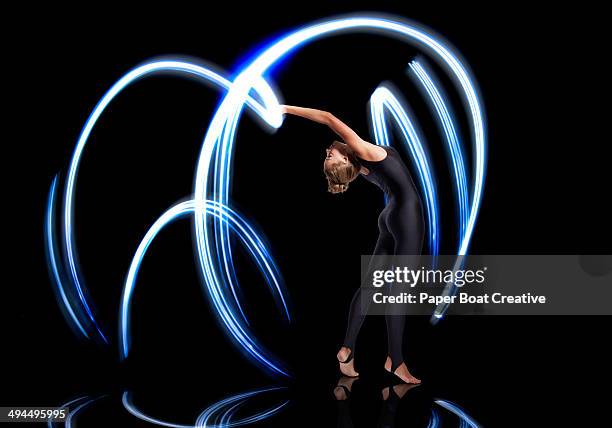 gymnast making electric blue light streaks - long exposure dance stock pictures, royalty-free photos & images