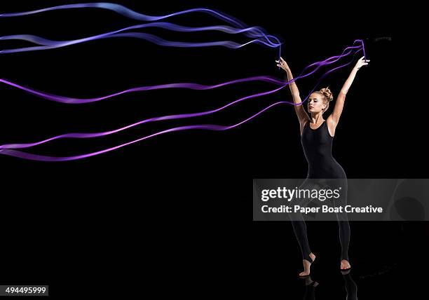 gymnast holding sets of blue and purple ribbons - ribbon dance stock pictures, royalty-free photos & images