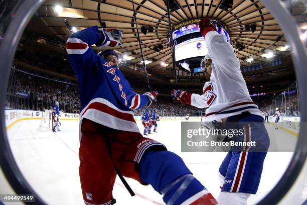 Kevin Klein of the New York Rangers and Rene Bourque of the Montreal Canadiens collide along the boards during Game Six of the Eastern Conference...