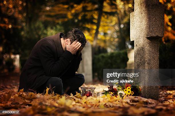 man in the cemetery - man cry touching stock pictures, royalty-free photos & images