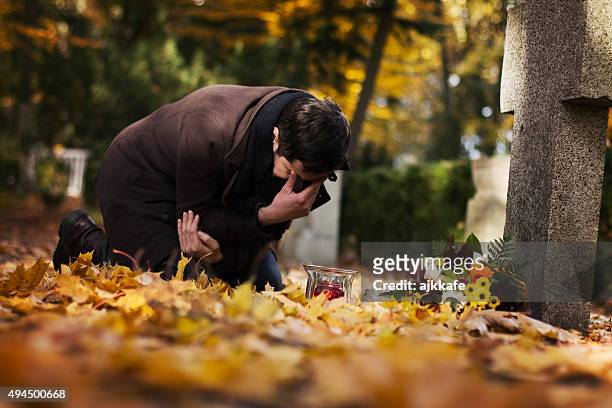 man in the cemetery - man cry touching stock pictures, royalty-free photos & images