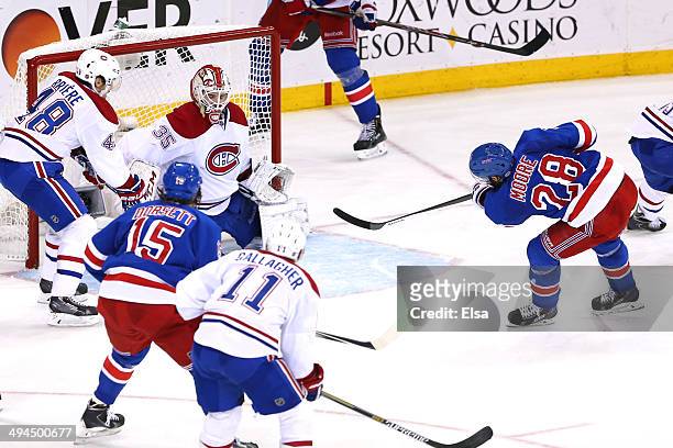 Dominic Moore of the New York Rangers scores a goal against Dustin Tokarski of the Montreal Canadiens in the second period during Game Six of the...