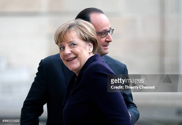 French President Francois Hollande welcomes German Chancellor Angela Merkel prior to a meeting at the Elysee Presidential Palace on October 27, 2015...