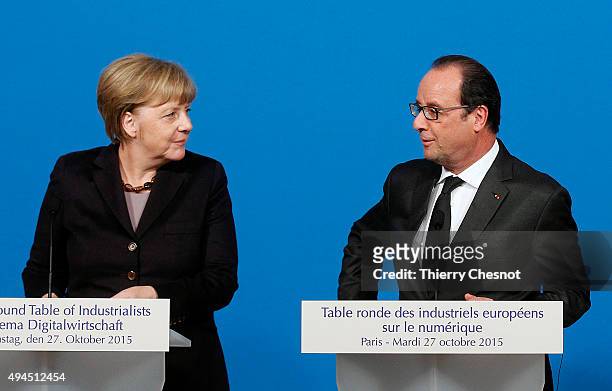 French President Francois Hollande talks with German Chancellor Angela Merkel during a press conference at the Elysee Presidential Palace on October...