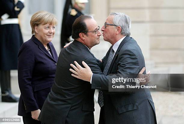 French President Francois Hollande and German Federal Chancellor welcome European Commission President Jean-Claude Juncker upon his arrival at the...