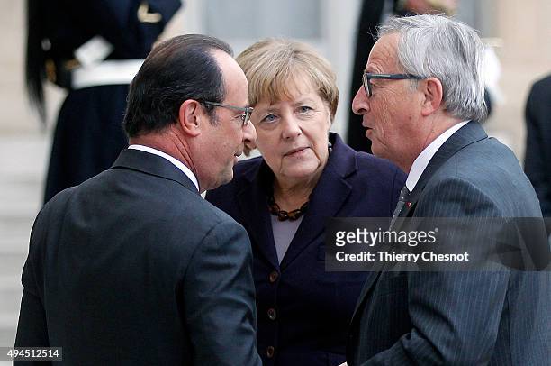 French President Francois Hollande and German Federal Chancellor welcome European Commission President Jean-Claude Juncker upon his arrival at the...