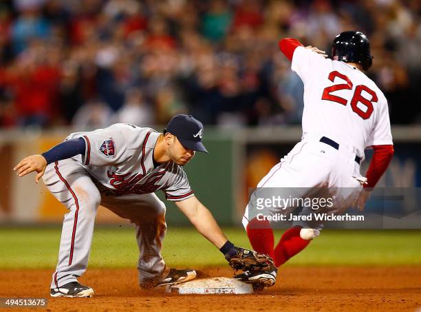 Tommy La Stella of the Atlanta Braves misses catching the throw at second base in front of Brock Holt of the Boston Red Sox that allowed the...