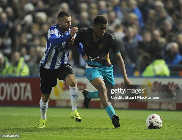 Alex Iwobi of Arsenal takes on Jack Hunt of Sheffield Wednesday during the Capital One Cup Fourth Round match between Sheffield Wednesday and Arsenal...