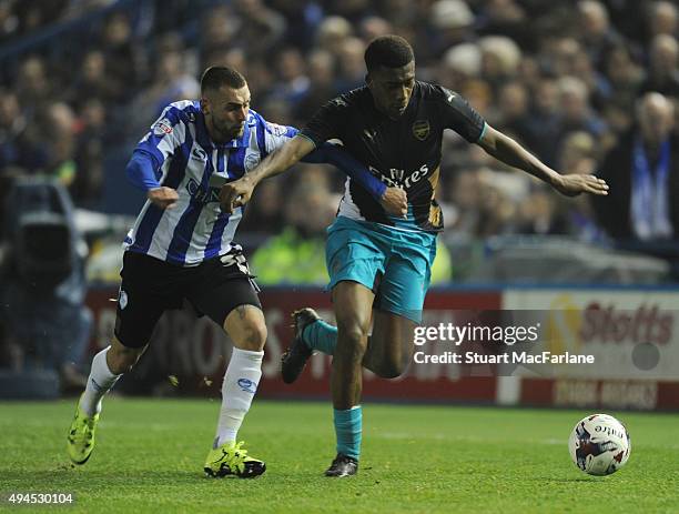 Alex Iwobi of Arsenal takes on Jack Hunt of Sheffield Wednesday during the Capital One Cup Fourth Round match between Sheffield Wednesday and Arsenal...