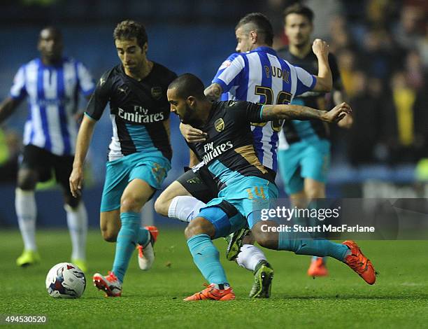 Theo Walcott of Arsenal challenged by Daniel Pudil of Sheffield Wednesday during the Capital One Cup Fourth Round match between Sheffield Wednesday...