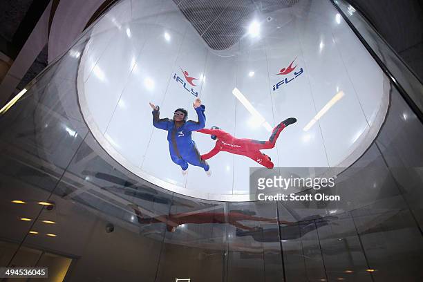 Flying instructor David Schnaible guides Patrece White as she learns wind tunnel flying at the iFly indoor skydiving facility on May 29, 2014 in...