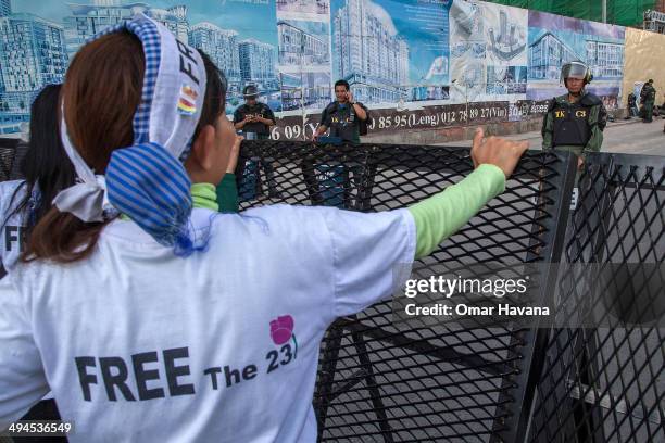 Activist Yorm Bopha shouts slogans to the security forces in front of one of the barricades set up near the Phnom Penh Municipal court to hear the...