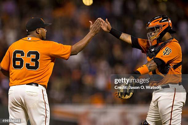 Jean Machi of the San Francisco Giants celebrates with Hector Sanchez after the game against the Minnesota Twins at AT&T Park on May 23, 2014 in San...