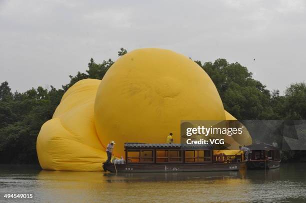 Workers set up a giant inflatable Rubber Duck designed by Dutch conceptual artist Florentijn Hofman at the Xixi National Wetland Park on May 29, 2014...