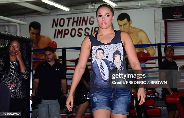 Mixed Martial Arts fighter Ronda Rousey, wearing a shirt with portraits of former heavyweight boxing champion Muhammad Ali and the late US singer...