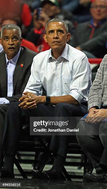 President Barack Obama sits courtside as the Chicago Bulls take on the Cleveland Cavaliers during the season opening game at the United Center on...