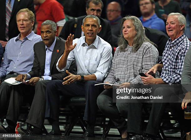 President Barack Obama sits courtside as the Chicago Bulls take on the Cleveland Cavaliers during the season opening game at the United Center on...