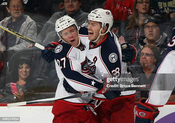 Boone Jenner of the Columbus Blue Jackets celebrates his third period goal against the New Jersey Devils along with Ryan Murray at the Prudential...
