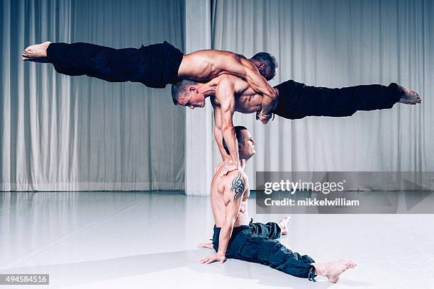 le travail d'équipe est une réussite, des acrobates utilisez votre force et votre équilibre - acrobatic activity photos et images de collection