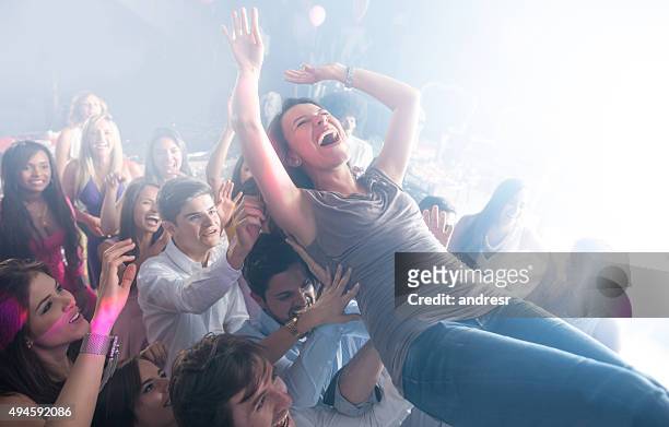 woman having fun at a concert - crowdsurfing stockfoto's en -beelden