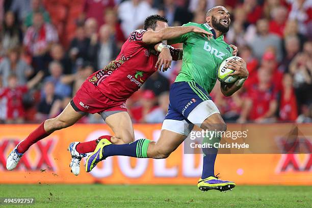 Patrick Osborne of the Highlanders makes a break from Rod Davies of the Reds to score a try of the during the round 16 Super Rugby match between the...