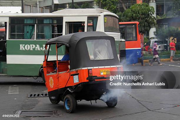 Heavy smoke pours from the exhaust of a three-wheeled bajaj on May 30, 2014 in Jakarta, Indonesia. Recent reports have ranked Jakarta behind Mexico...