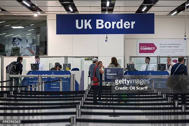 Border Force check the passports of passengers arriving at Gatwick Airport on May 28, 2014 in London, England. Border Force is the law enforcement...