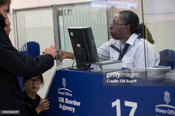 Border Force check the passports of passengers arriving at Gatwick Airport on May 28, 2014 in London, England. Border Force is the law enforcement...