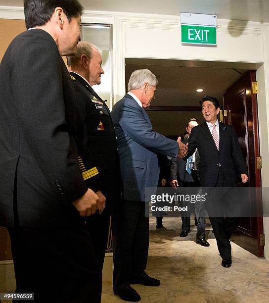 Defense Secretary Chuck Hagel greets Japanese Prime Minister Shinzo Abe as Japanese Defense Minister Itsunori Onodera and Gen. Martin Dempsey,...