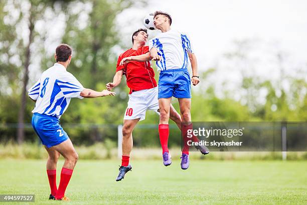 soccer players heading the ball. - heading stock pictures, royalty-free photos & images